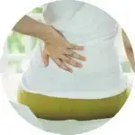 Person wearing a white t-shirt suffers low back pain.