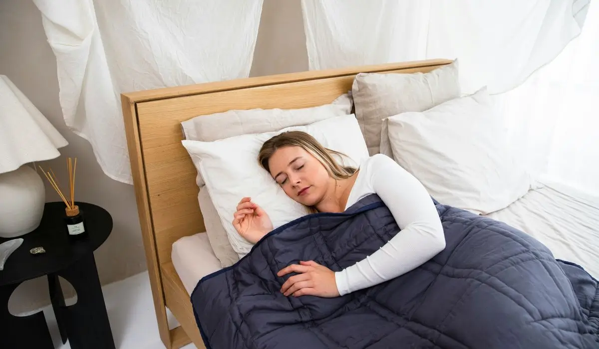 Side-sleeping woman with pillow support, a recommended position for managing nighttime sciatica pain and reducing nerve compression.