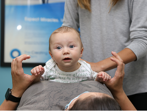 Chiropractor providing gentle infant chiropractic care to a baby patient in a calm clinical setting