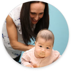 Dr. Katie Sleigh providing gentle chiropractic care to an infant in a calm, family-focused clinic setting
