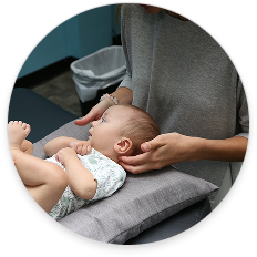 Chiropractor providing gentle infant chiropractic care in a calm clinical environment