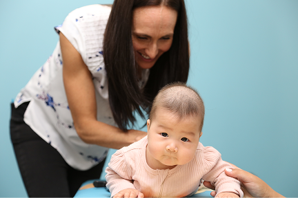 Dr. Katie Sleigh welcoming a new pediatric patient during a gentle infant chiropractic visit