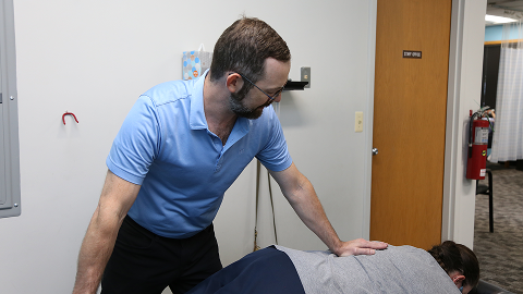 Chiropractor providing gentle, supportive chiropractic care for a patient with osteoporosis in a clinical setting