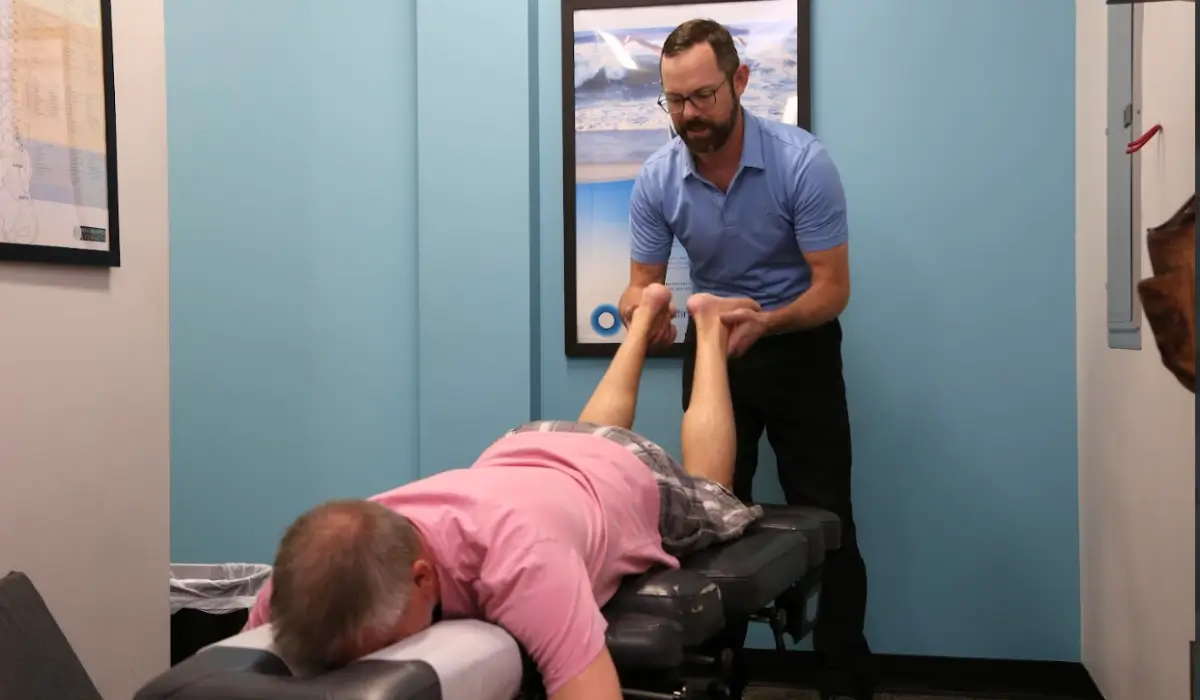 Chiropractor adjusting senior patient’s legs to provide chiropractic help for arthritis and reduce inflammation.