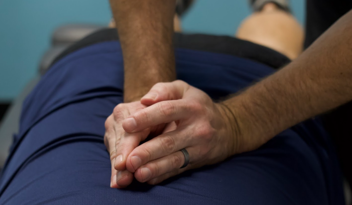Hands performing spinal adjustment demonstrating the science behind adjustments and controlled joint alignment correction.