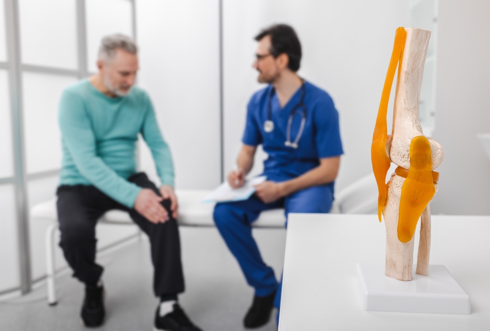 Top-down view of a female chiropractor performing a gentle adjustment on a pregnant patient lying on a specialized chiropractic table.