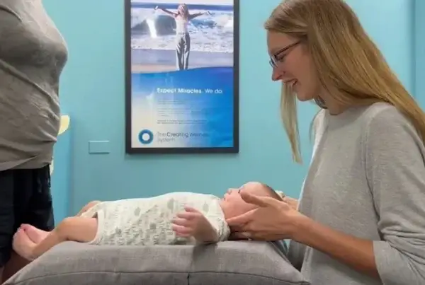 A chiropractor holding a baby's head. Pediatric Chiropractic Care in Illinois.
