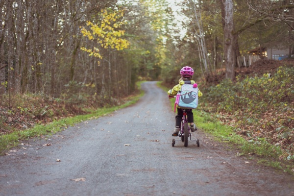 A child happily riding a bike on a peaceful country road