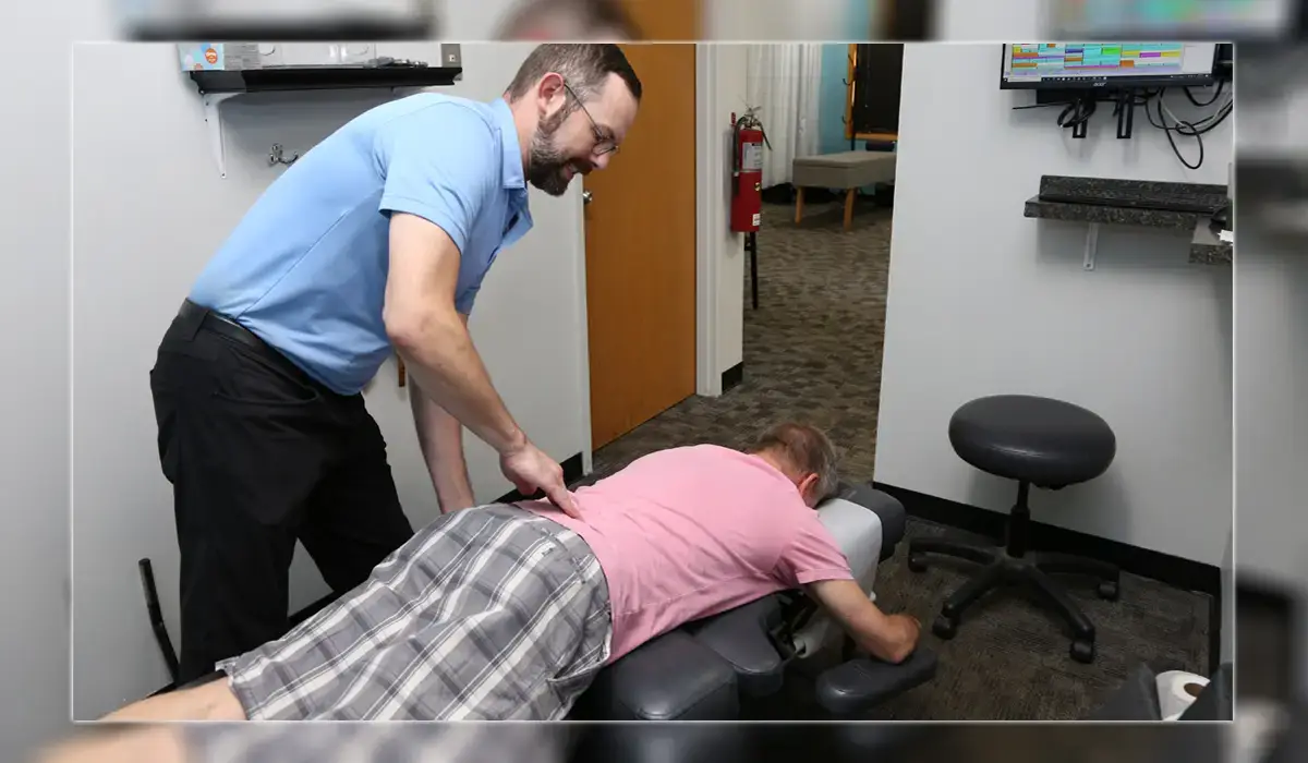 A man adjusts a person's back pain. Sciatica and chiropractic care in Illinois.