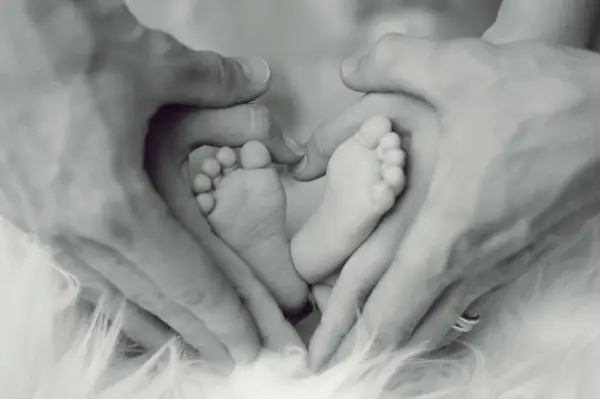 A close-up shot of a newborn's feet, captured in black and white.