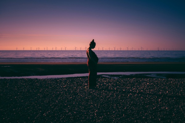 A woman enjoying the sunset on the beach